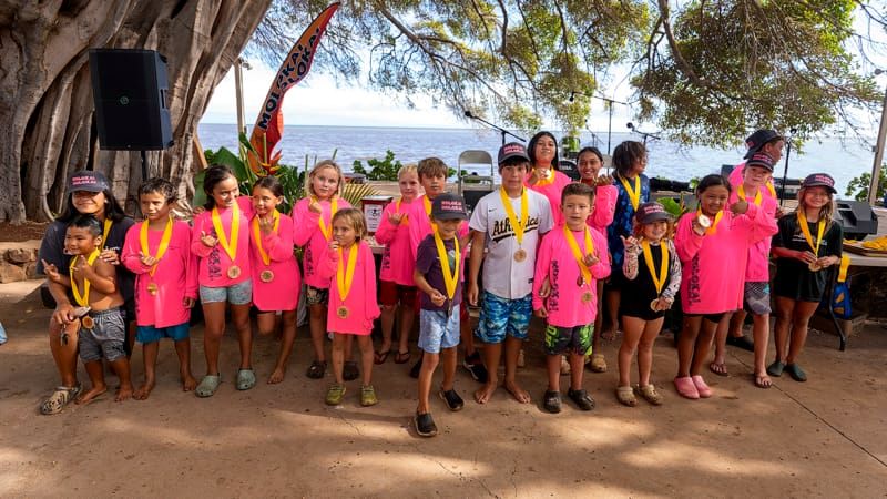 Keiki proudly wear medals under the banyan tree